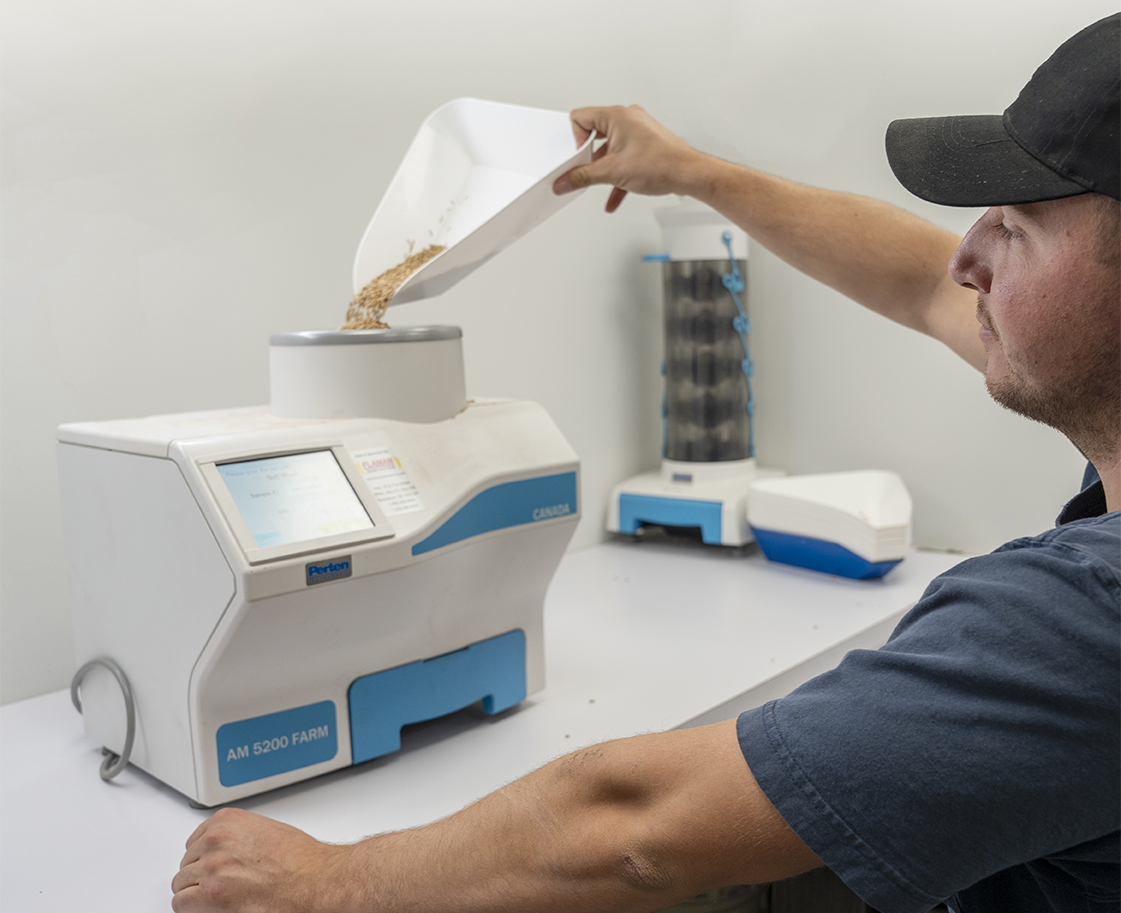 Photo of man pouring sample into Perten 5200-Farm moisture meter